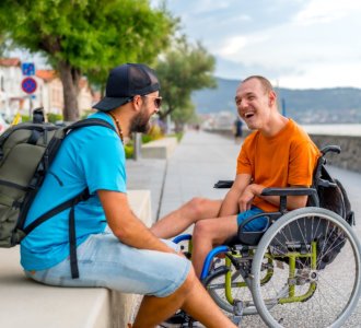 person in wheelchair with friends on summer vacation having fun